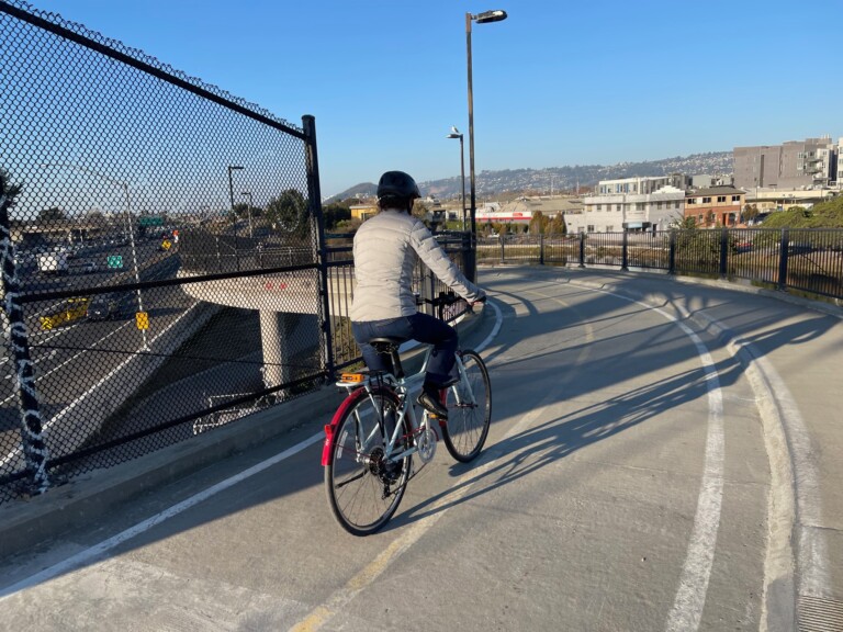 A cyclist rides on the I-80 bicycle bridge in Berkeley, California. California’s 2025 budget prioritizes freeways over safe streets. Photo by Dave Iltis